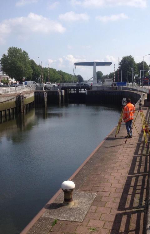 Een medewerker van Iv verricht specialistische metingen aan een sluis