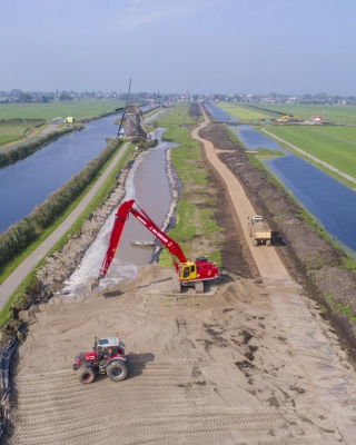 Luchtfoto van de versterking van de regionale waterkering Molenkade nabij Groot-Ammers met werkzaamheden aan het watersysteem, grondlichamen en oeverconstructies.